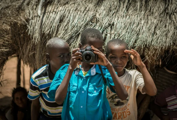 Kids playing with a camera. Be a respectful traveler in Africa