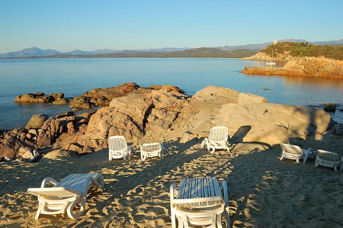 Lounge chairs in a sandy area in Hotel Arbatax Park. Best  eco-friendly hotels in Italy.